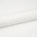Nahaufnahme eines weißen, texturierten Spa-Handtuchs mit weicher Faserstruktur.