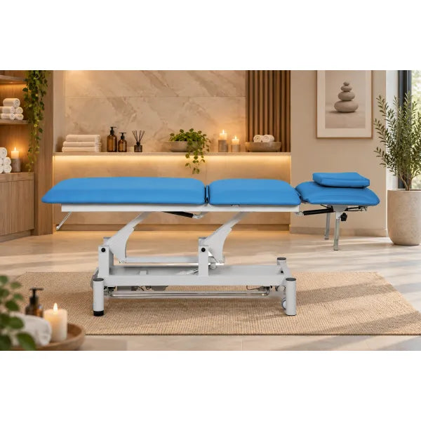 Elektrische Kosmetikliege mit blauem Polster und Motor-Hydraulikgestell für Massage und Behandlung im professionellen Wellnessstudio.