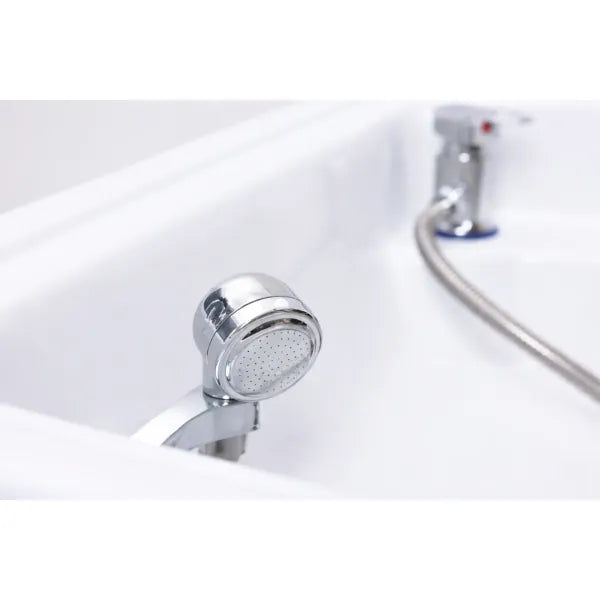 Verchromter Brausekopf am weißen Waschbecken mit flexiblem Schlauch – Kopfspa-Setup.