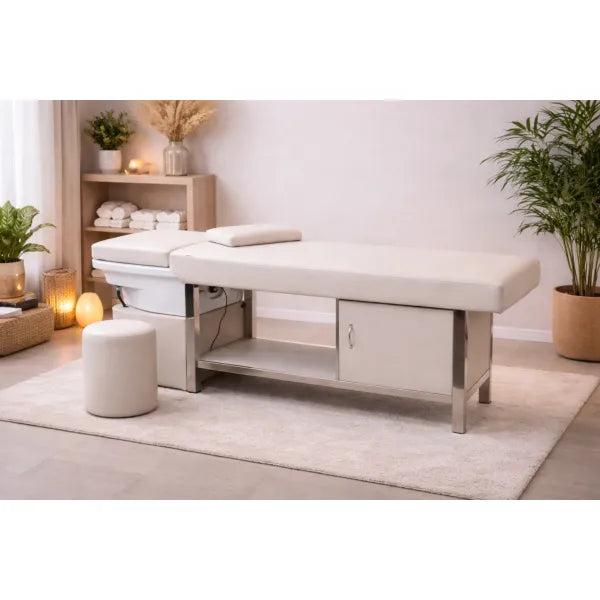 Beige Kopfspa-Liege aus Edelstahl mit Keramik-Waschbecken im Spa-Salon, umgeben von Pflanzen.