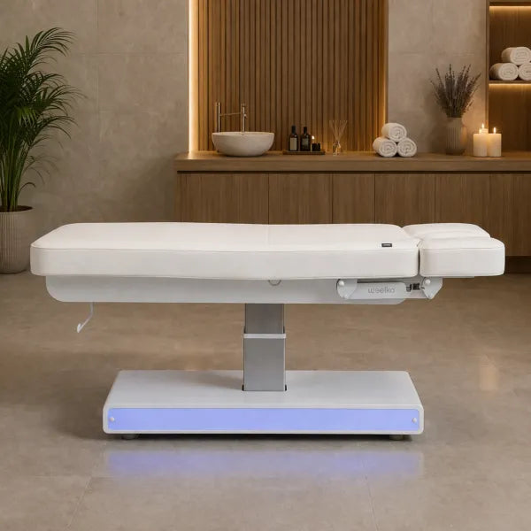 Weiße elektrische Massageliege NUSH+ mit drei Motoren, Spa- und Kosmetikliege, Sockel im Wellness-Studio.