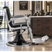 Vintage Barberstuhl Schwarz-Silber mit hydraulischer Verstellung, Fussstütze und klassischem Design im Friseursalon.