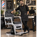 Vintage Barberstuhl Schwarz-Silber, hydraulisch verstellbar, professioneller Herren-Friseurstuhl im Barbershop mit Friseur.