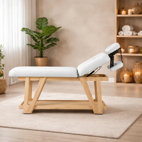 Holz-Massageliege mit weißem Polster und separatem Kopfteil. Robuste 2-Zonen Spa-Liege für Wellness & Kosmetik.