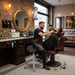 Friseur bedient Kunde mit Sattelhocker ACTION – ergonomischer, höhenverstellbarer Rollhocker für Salon & Kosmetik.