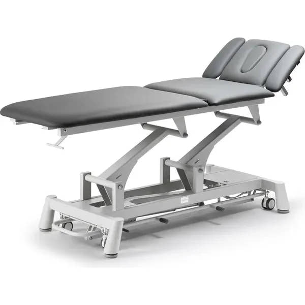 Seitliche Ansicht der TITAN 304F Therapieliege in Grau mit Kopfstütze, Armauflagen und 3 Hauptsegmenten.