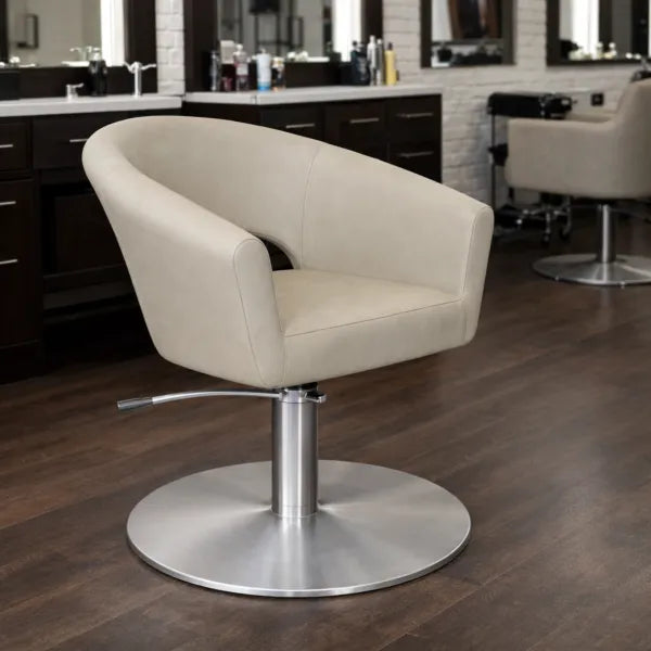 Friseurstuhl Cosmo: Luxuriöser, eleganter Salonstuhl mit beiger Polsterung und Edelstahl-Rundfuß.
