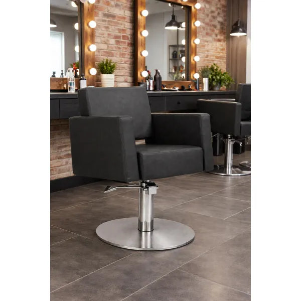 Friseurstuhl Flirty – eleganter Profi-Salonstuhl mit Hydraulikpumpe, schwarzes Polster, runder Metallfuß im modernen Studio.
