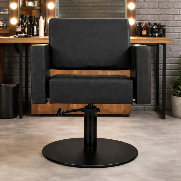 Friseurstuhl Flirty – eleganter, schwarzer Profi-Friseurstuhl mit Hydraulikpumpe und Armlehnen im Salon.