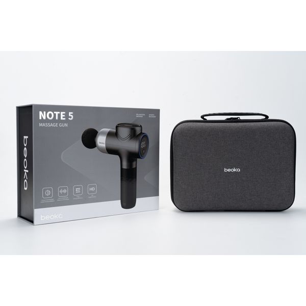 NOTE 5 Massagepistole Box mit Akku und 5 Köpfen neben grauem Beoka-Tragekoffer