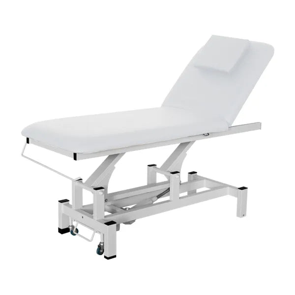 Therapist performs back massage on client on a height-adjustable electric massage bed in a spa setting.