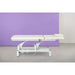 Electric massage table with one motor, height-adjustable treatment bed against a purple backdrop