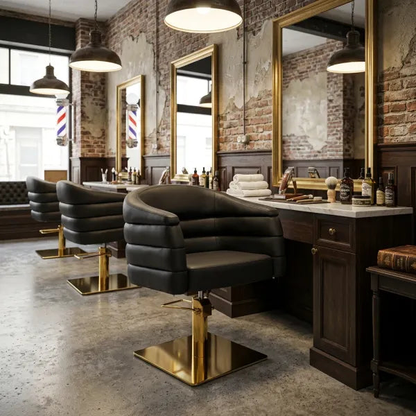Schwarzer hydraulischer Friseurstuhl mit Armlehnen und goldenem Gestell in einem modernen Barber Shop.