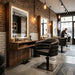 Schwarzer hydraulischer Friseurstuhl mit Armlehnen vor Holzspiegel mit LED-Licht im modernen Barbershop-Interieur.