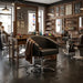 Schwarzer Friseurstuhl mit Armlehnen und hydraulischer Verstellung in einem BarberShop mit Holzspiegel und Ziegelwand.