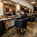 Schwarzer Friseurstuhl mit Goldfuß im Barbershop: Moderner Stylingstuhl mit Polsterung für professionellen Salonalltag.