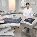 Pressotherapie-Gerät Hightech Air Flow mit 12-Kammer-Kompressionssystem, Touchscreen und Beinmanschetten im Behandlungsraum.