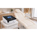 Pressotherapie-Gerät Hightech Air Flow mit 12-Kammer-Kompressionssystem, Beinmanschetten und Touchscreen neben Kosmetikstuhl.