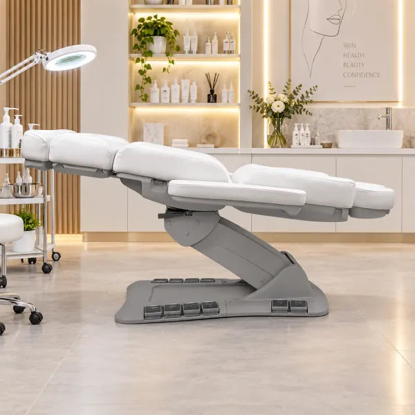 Elektrische weiße Kosmetikliege mit 4 Motoren und Heizung im modernen Beauty-Studio. Professionelle Behandlungsliege für Salontherapien.