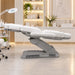 Elektrische weiße Kosmetikliege mit 4 Motoren und Heizung im modernen Beauty-Studio. Professionelle Behandlungsliege für Salontherapien.