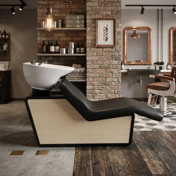 Modernes Rückwärtswaschbecken mit Keramikschale und schwarzem Lederpolster im stylischen Friseursalon-Design.