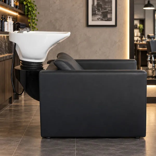 Premium Rückwärtswaschbecken mit elektrischer Fußstütze auf schwarzem Ledersitz im modernen Friseursalon.