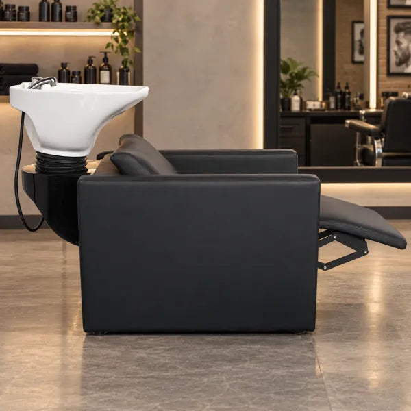 Black Friseurwaschbecken mit elektrischer Fußstütze und Massagefunktion im modernisierten Friseursalon.